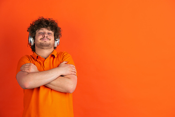 Image showing Caucasian young man\'s monochrome portrait on orange studio background