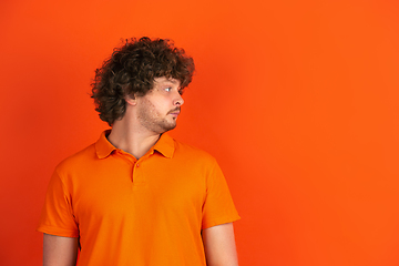 Image showing Caucasian young man\'s monochrome portrait on orange studio background