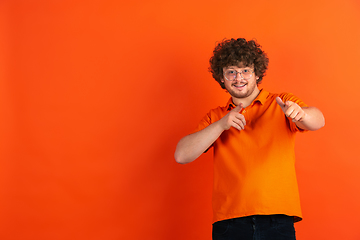 Image showing Caucasian young man\'s monochrome portrait on orange studio background