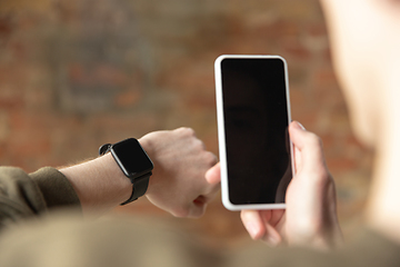 Image showing Close up of male hands using smartphone and smartwatch, education and business concept, blank screen