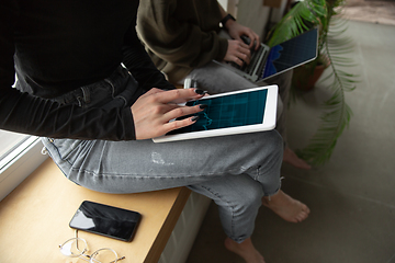 Image showing Close up of two people, couple using smartphone, laptop, smartwatch, education and business concept, communication during self-insulation