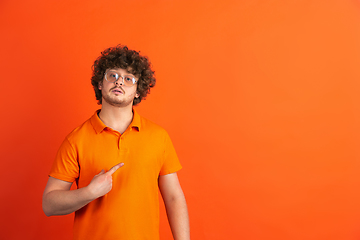 Image showing Caucasian young man\'s monochrome portrait on orange studio background