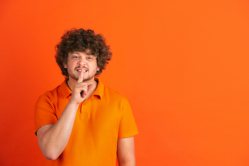 Image showing Caucasian young man\'s monochrome portrait on orange studio background