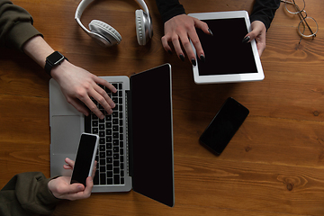 Image showing Close up of two people, couple using smartphone, laptop, smartwatch, education and business concept. Communication during self-insulation, top view, copyspace