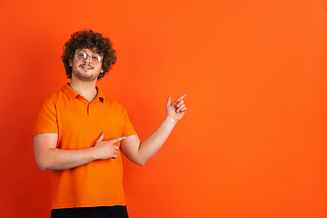 Image showing Caucasian young man\'s monochrome portrait on orange studio background