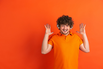 Image showing Caucasian young man\'s monochrome portrait on orange studio background