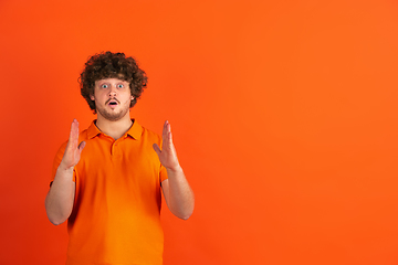 Image showing Caucasian young man\'s monochrome portrait on orange studio background