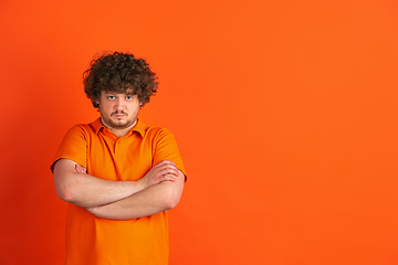 Image showing Caucasian young man\'s monochrome portrait on orange studio background