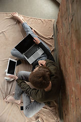 Image showing Attractive young couple using devices together, tablet, laptop, smartphone, headphones wireless. Gadgets and technologies connecting people all around the world. Top view