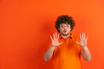 Image showing Caucasian young man\'s monochrome portrait on orange studio background