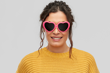 Image showing smiling young woman in heart-shaped sunglasses