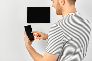 Image showing man with smartphone and tablet pc at smart home