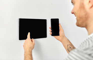 Image showing man with smartphone and tablet pc at smart home