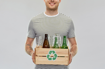 Image showing smiling young man sorting glass waste