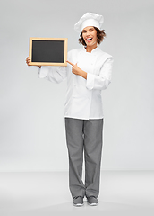 Image showing smiling female chef holding black chalkboard