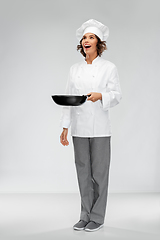 Image showing smiling female chef in toque with frying pan