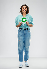 Image showing smiling young woman holding green recycling sign