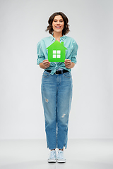 Image showing smiling young woman holding green house