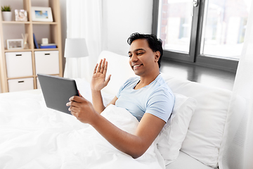 Image showing happy man with tablet pc in bed having video call