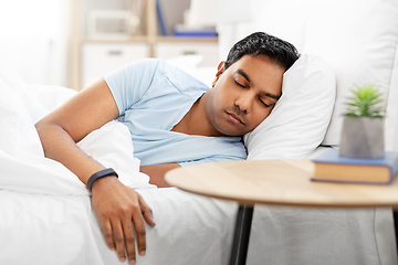 Image showing indian man with tracker sleeping in bed at home