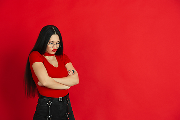 Image showing Caucasian young woman\'s monochrome portrait on red studio background, emotional and expressive