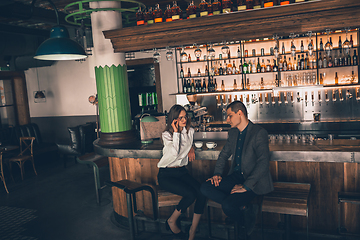 Image showing Cheerful man and woman talking, enjoying a coffee at the coffee shop, cafe, bar