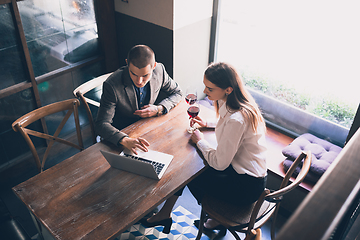 Image showing Cheerful man and woman talking, enjoying a wine at the wine shop, cafe