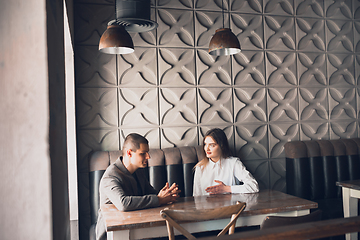 Image showing Cheerful man and woman talking, discussing at the coffee shop, cafe