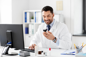 Image showing male doctor with medicine and computer at hospital