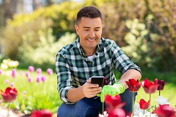 Image showing middle-aged man with smartphone at flower garden