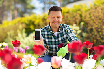 Image showing middle-aged man with smartphone at flower garden