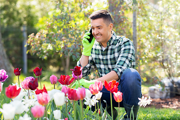 Image showing man with flowers calling on smartphone at garden