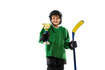 Image showing Little hockey player with the stick on ice court and white studio background