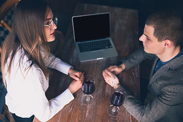 Image showing Cheerful man and woman talking, enjoying a wine at the wine shop, cafe