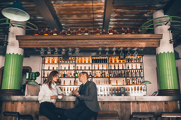 Image showing Cheerful man and woman talking, enjoying a coffee at the coffee shop, cafe, bar