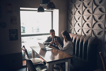 Image showing Cheerful man and woman talking, enjoying a wine at the wine shop, cafe