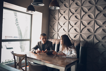 Image showing Cheerful man and woman talking, discussing at the coffee shop, cafe