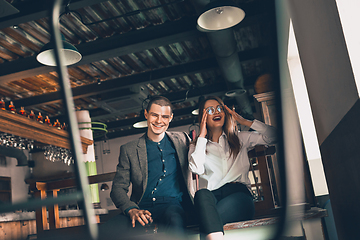 Image showing Cheerful man and woman talking, enjoying, having fun at bar, cafe