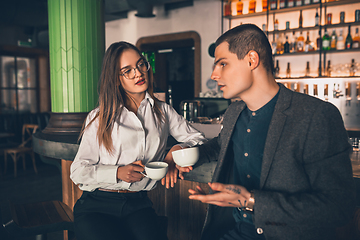 Image showing Cheerful man and woman talking, enjoying a coffee at the coffee shop, cafe, bar