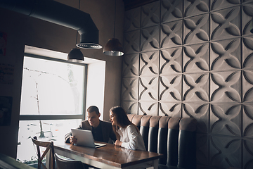 Image showing Cheerful man and woman talking, working at the coffee shop, cafe