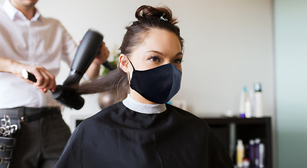 Image showing happy woman with stylist making hairdo at salon