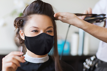 Image showing happy woman with stylist making hairdo at salon