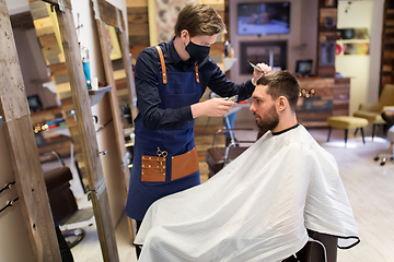 Image showing man and barber with trimmer cutting hair at salon