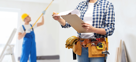 Image showing woman with clipboard, pencil and working tools