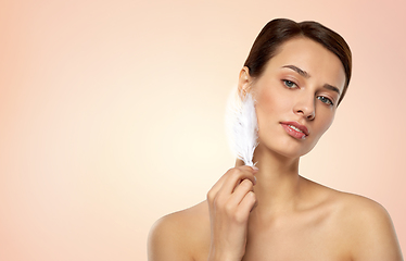 Image showing beautiful woman with feather touching her face