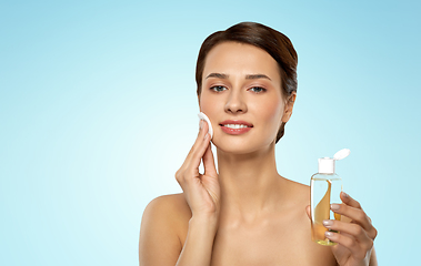 Image showing young woman with toner or cleanser and cotton pad