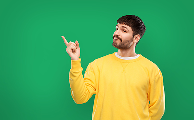 Image showing man pointing finger to something over green