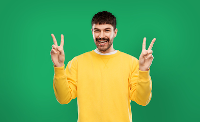 Image showing young man showing peace over grey background