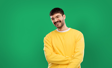 Image showing smiling young man in glasses and yellow sweatshirt