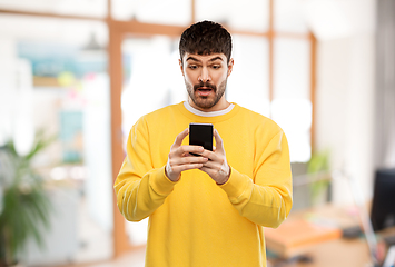 Image showing surprised young man with smartphone